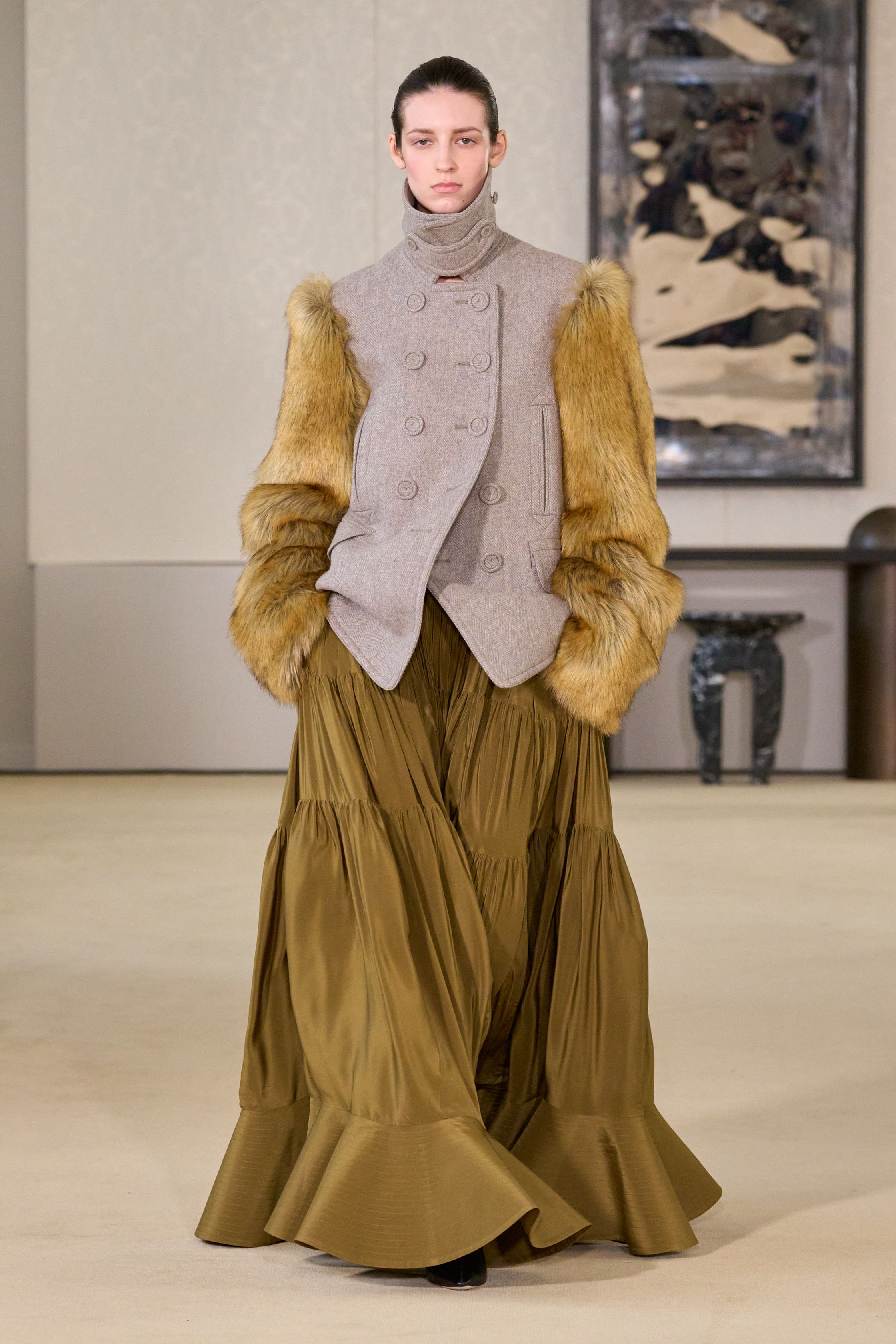 Altuzarra以克制而精准的剪裁回应都市女性的力量命题，皮革长裙、毛领外套与细节扣饰勾勒冷静轮廓，在黑棕与灰调之间展现成熟而富有策略性的优雅，将性感与权威融为一体-顽石频道趋势研究